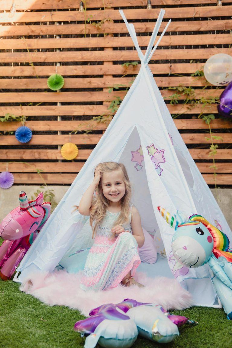 A joyful girl in a unicorn-themed party setting, surrounded by colorful decorations.